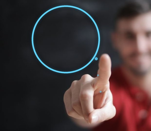 A person's pointing hand with a clean glowing circle drawn in the air from the fingertip.